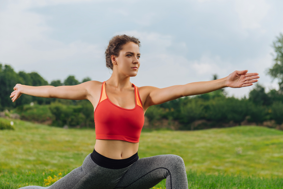 A woman practices yoga on grass, promoting wellness and mindfulness, with Revity Medical branding in the background.