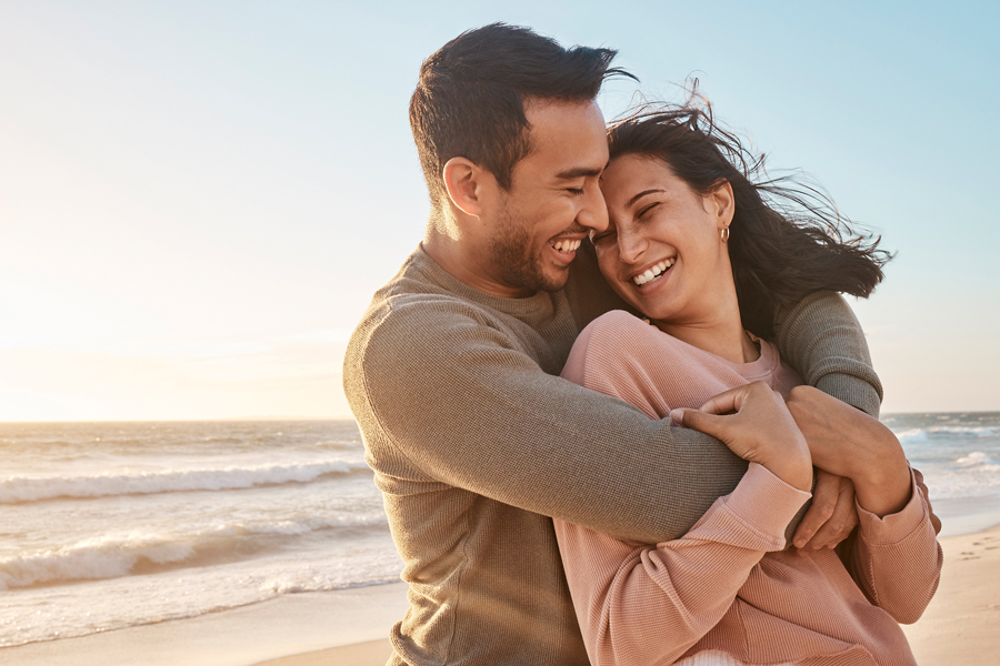 A man and woman embrace on the beach, symbolizing connection and warmth, with Revity Medical branding in the background.
