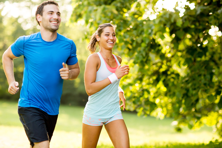 A man and woman jogging together in a park, promoting fitness and well-being, with Revity Medical branding visible.