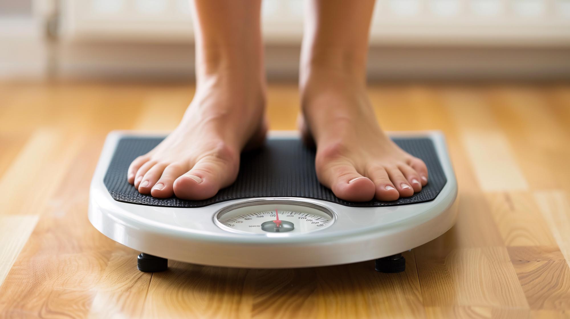 A person stands on a scale with their feet on the floor, representing health monitoring by Revity Medical.