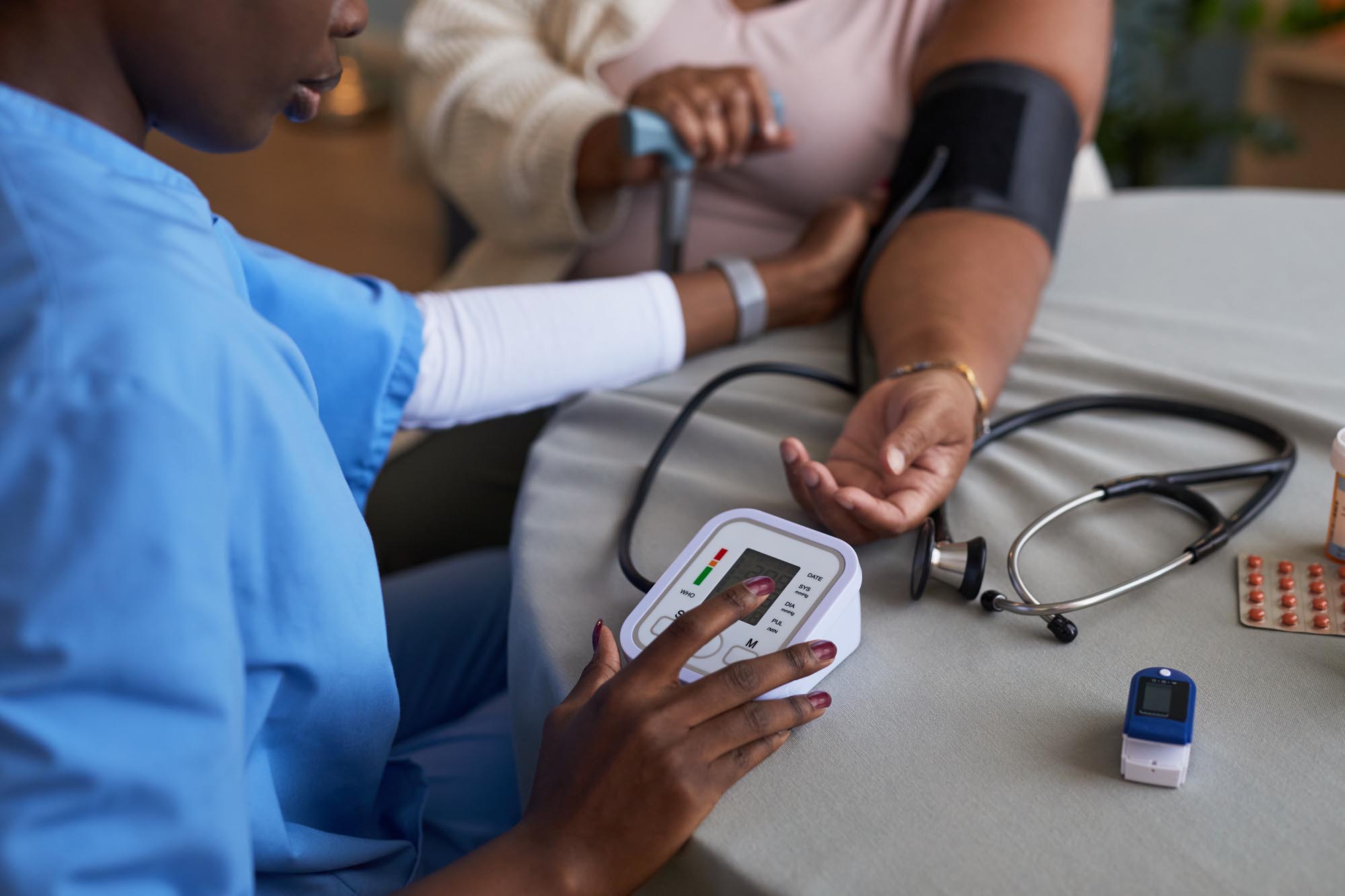 A nurse at Revity Medical checks a patient's blood pressure with a sphygmomanometer in a clinical setting.