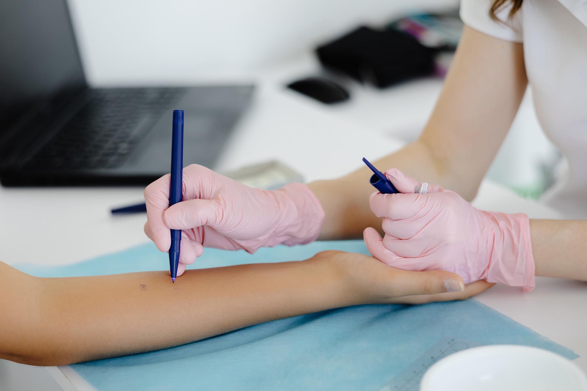 A woman receives a tattoo on her arm from a doctor at Revity Medical, showcasing a professional tattooing process.